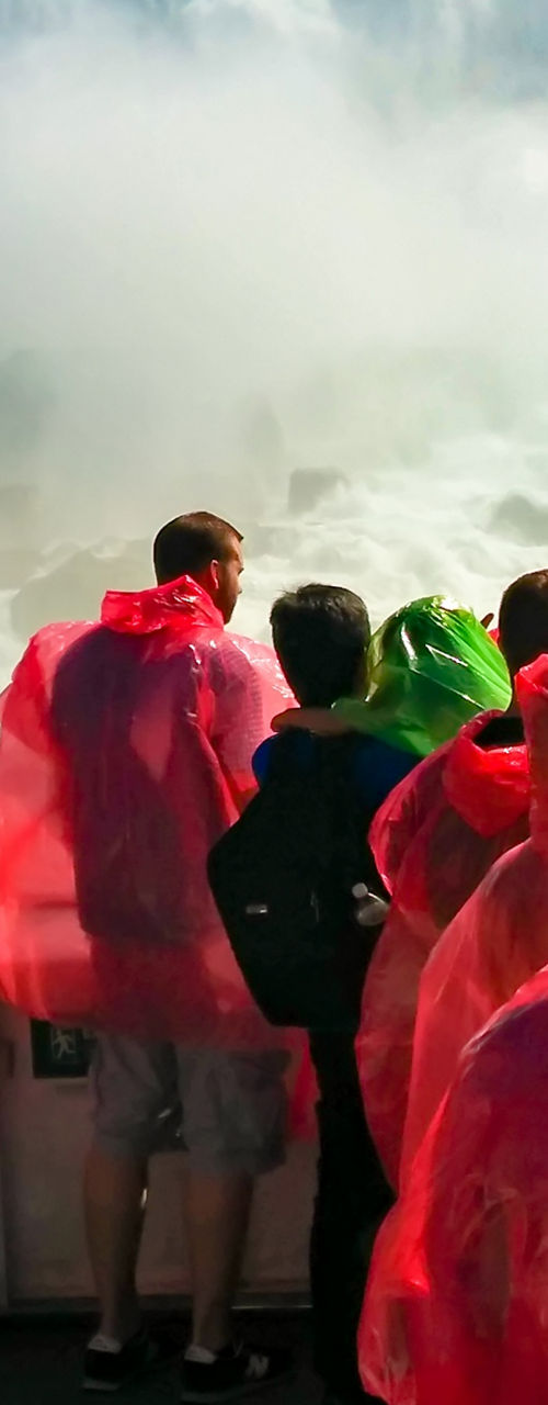 Tourists in red ponchos at waterfall