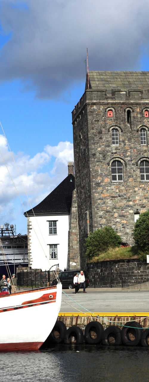 Historic waterfront with sailboat and stone building