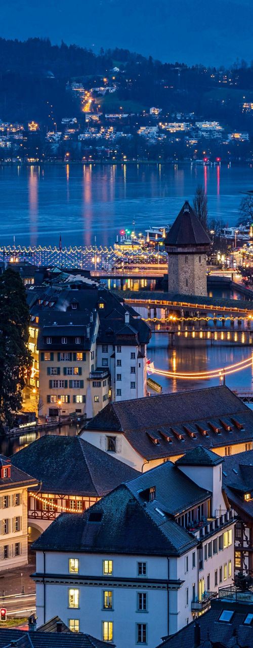 Nighttime cityscape of Lucerne with mountains