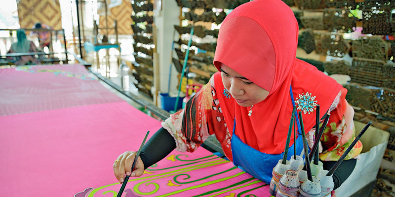 Artisan painting vibrant textile design