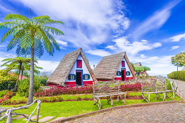 Traditional A-frame cottages in lush garden
