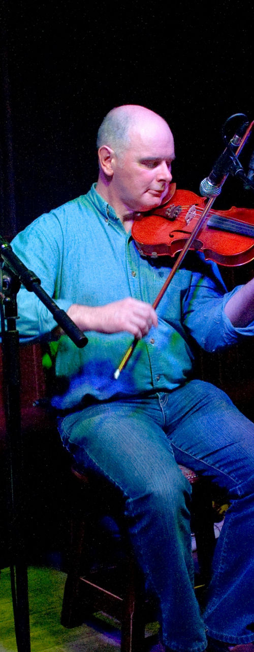 Three musicians performing live in pub