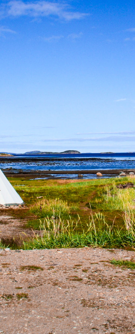 Teepees by a serene lakeside view