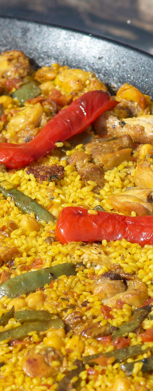 Traditional paella cooked outdoors on fire