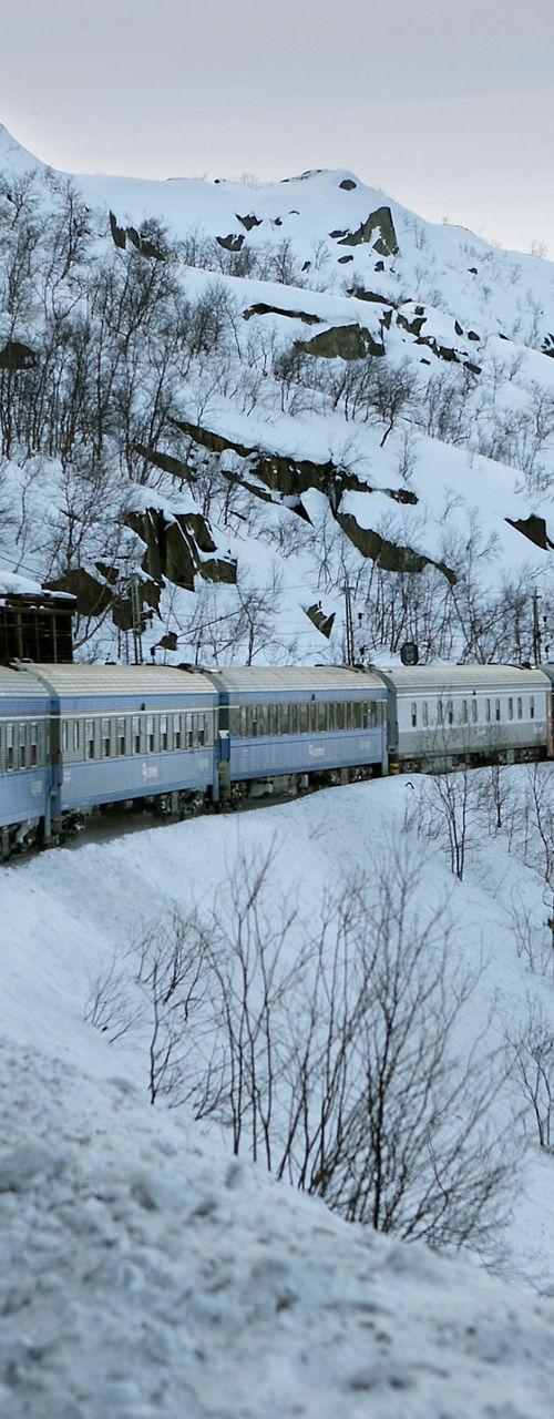 Train winding through snowy mountain landscape