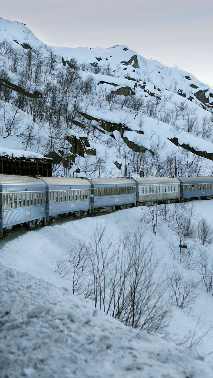 Train winding through snowy mountain landscape