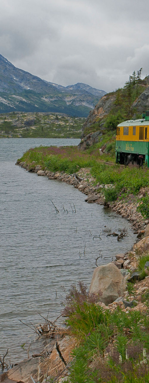 Scenic train ride by mountain lake