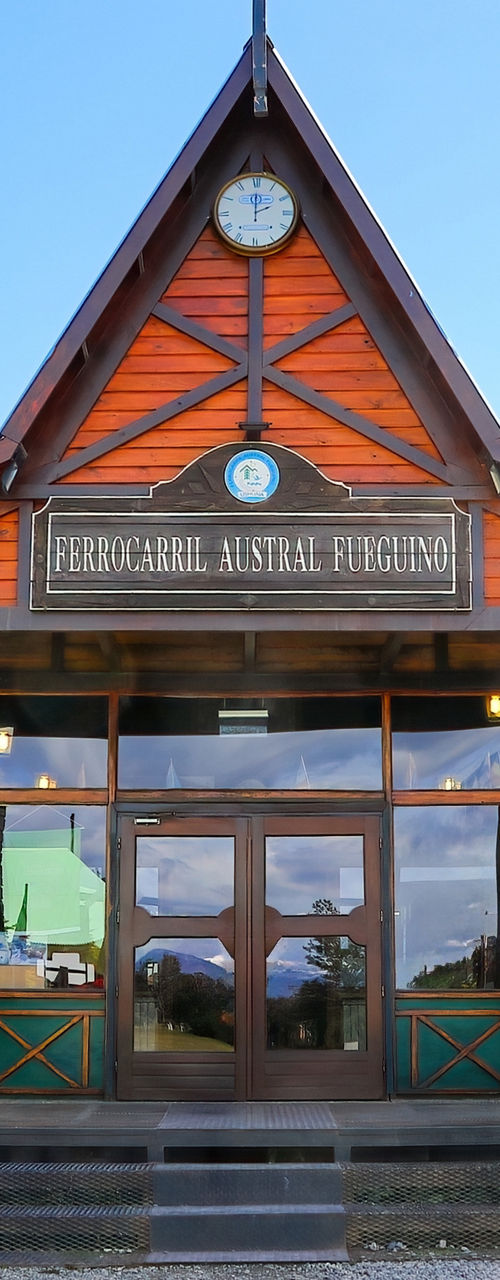 Wooden mountain lodge with flags under blue sky