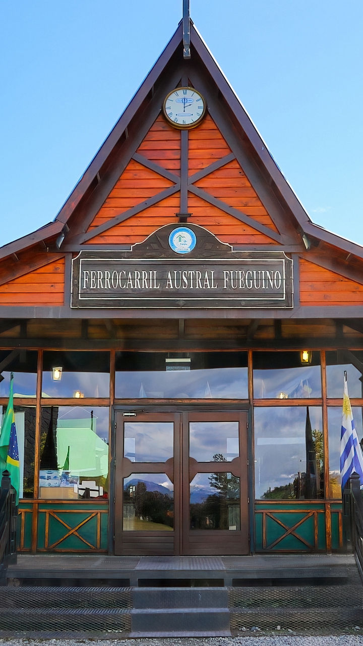 Wooden mountain lodge with flags under blue sky