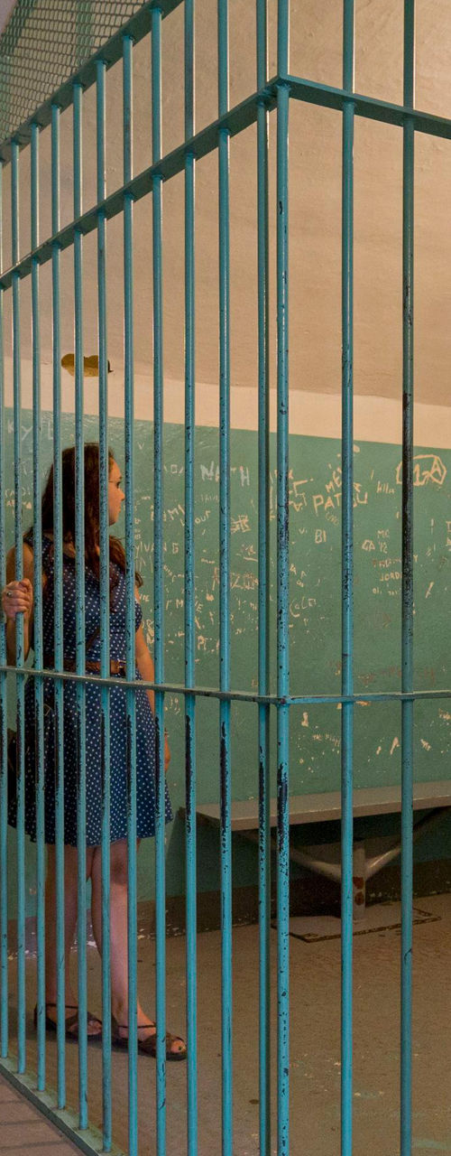 Woman inside vintage jail cell setting