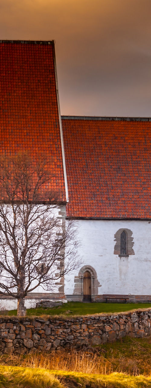 Historic white church with red roof at sunset