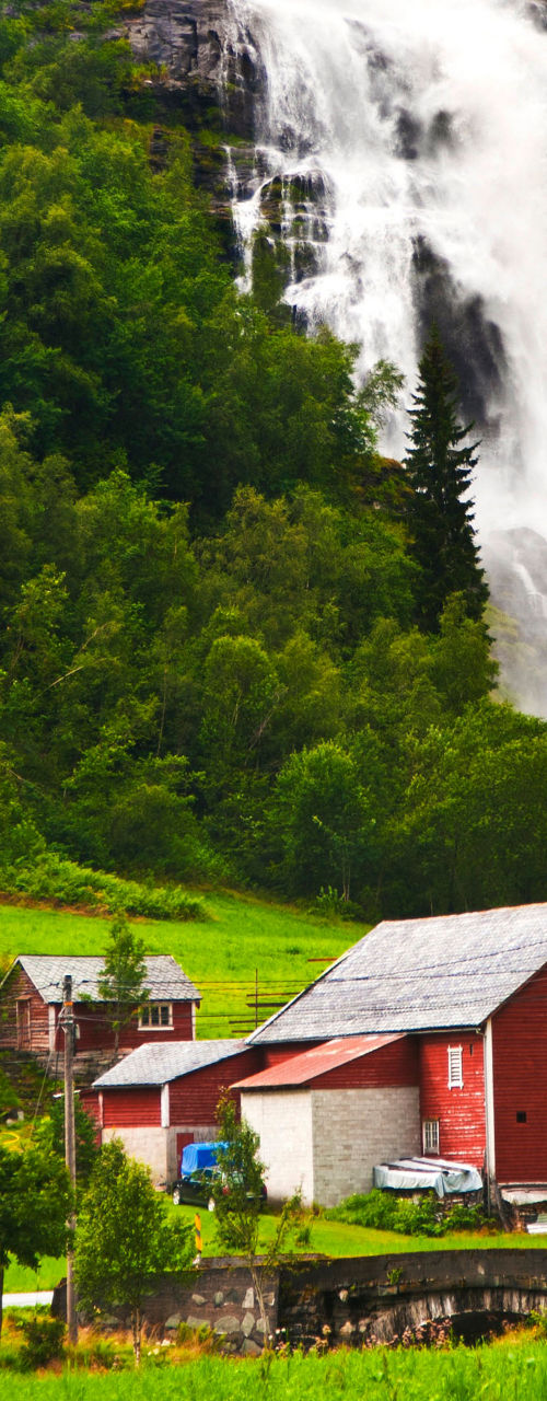 Scenic waterfall near rural red house
