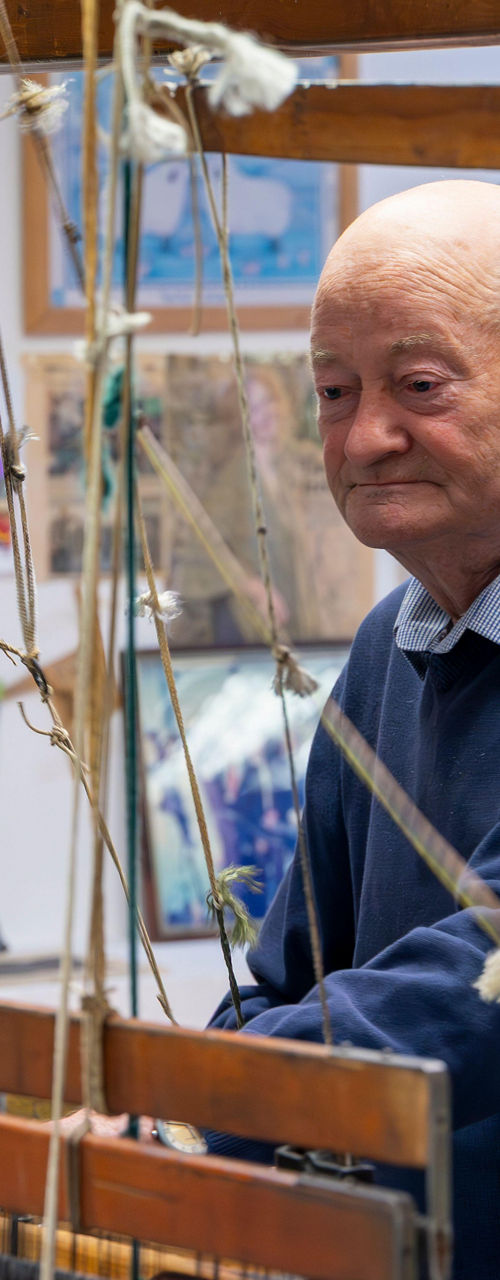 Elderly man operating traditional wooden loom