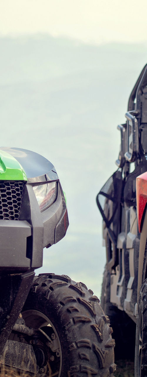 Green and red off-road utility vehicles outdoors