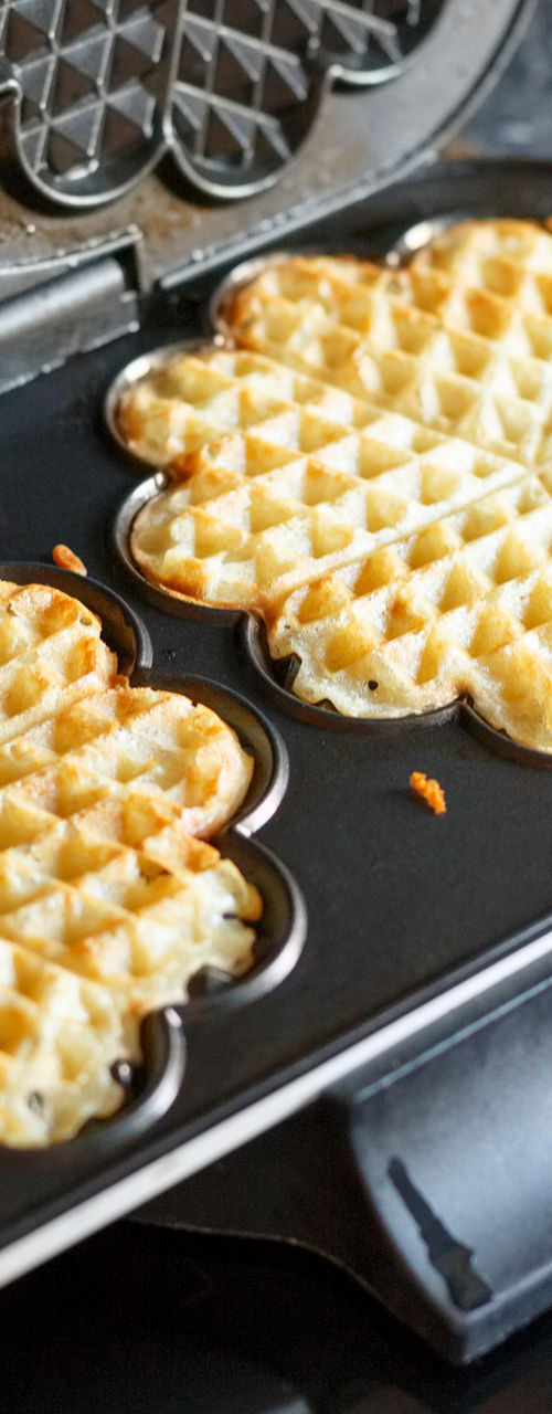 Heart-shaped waffles cooking in waffle maker