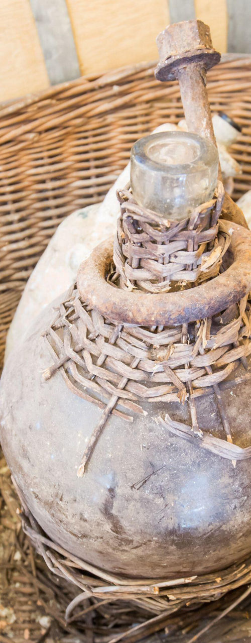 Rustic wicker basket with vintage bottles