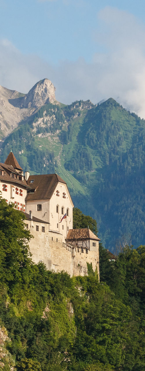 Medieval hilltop castle against alpine mountains