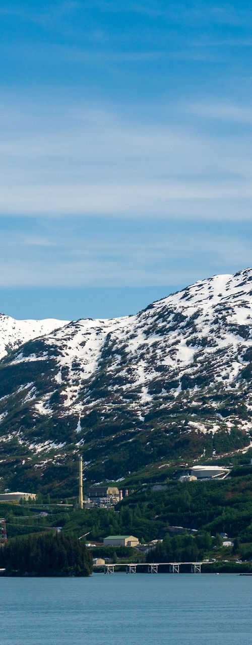 Snow-capped mountains by serene blue lake