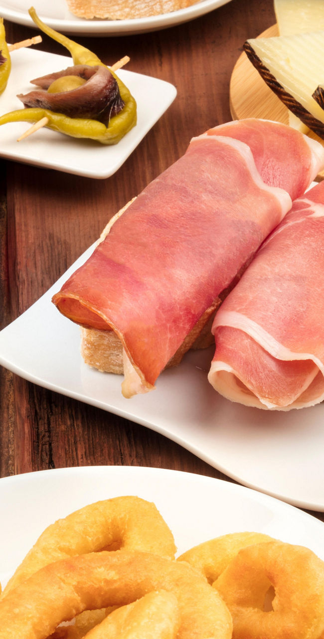 Assorted Spanish tapas with wine glass
