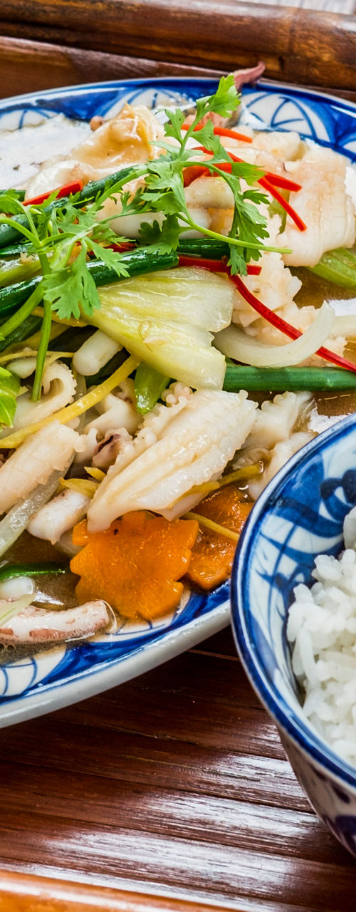 Asian stir-fry with rice on wooden tray
