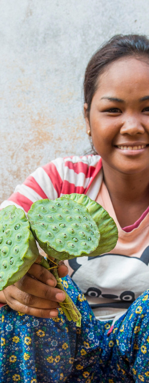 Woman holding lotus pods at market