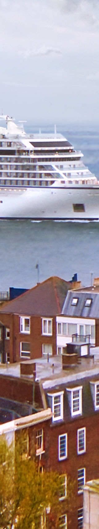 Cruise ship near coastal town skyline