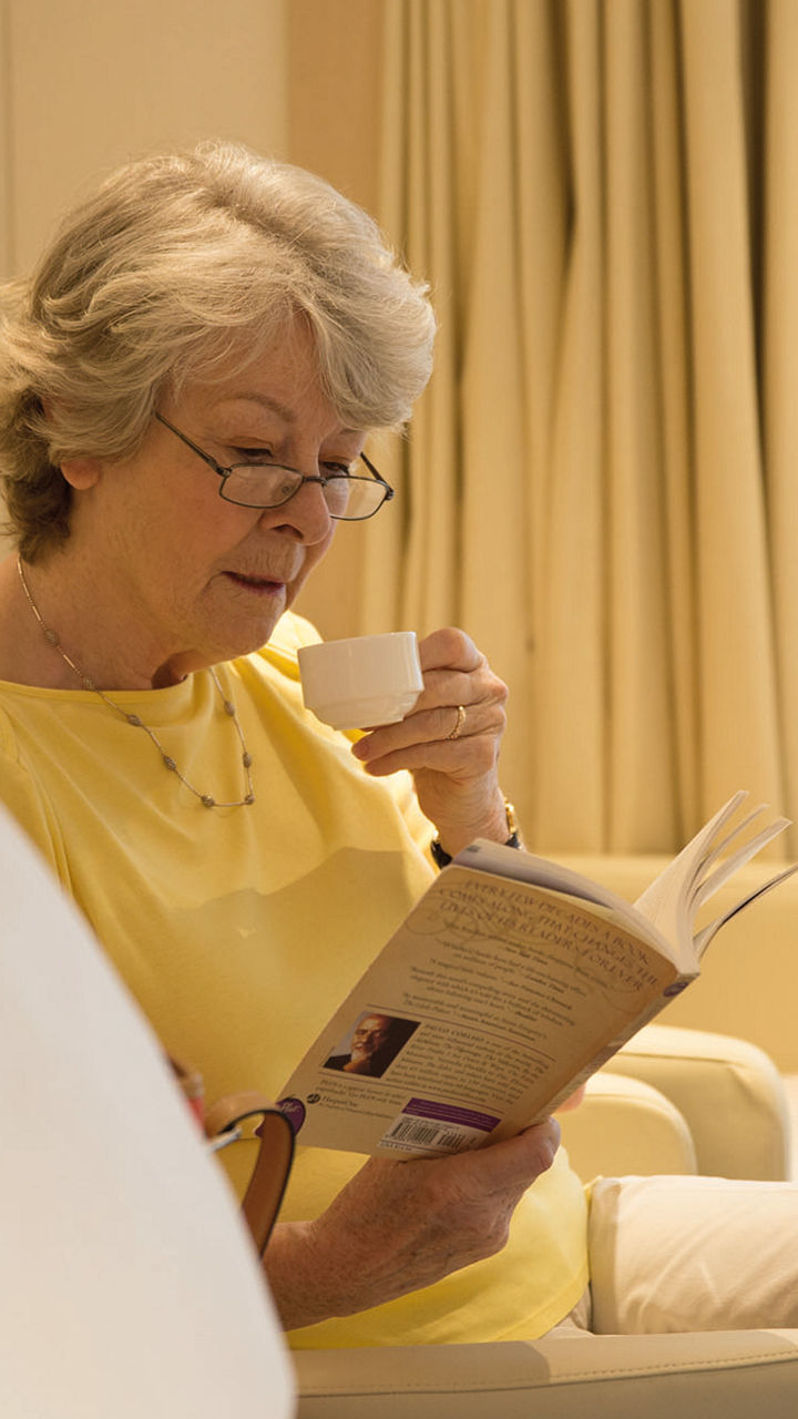 Elderly woman reading in cozy room
