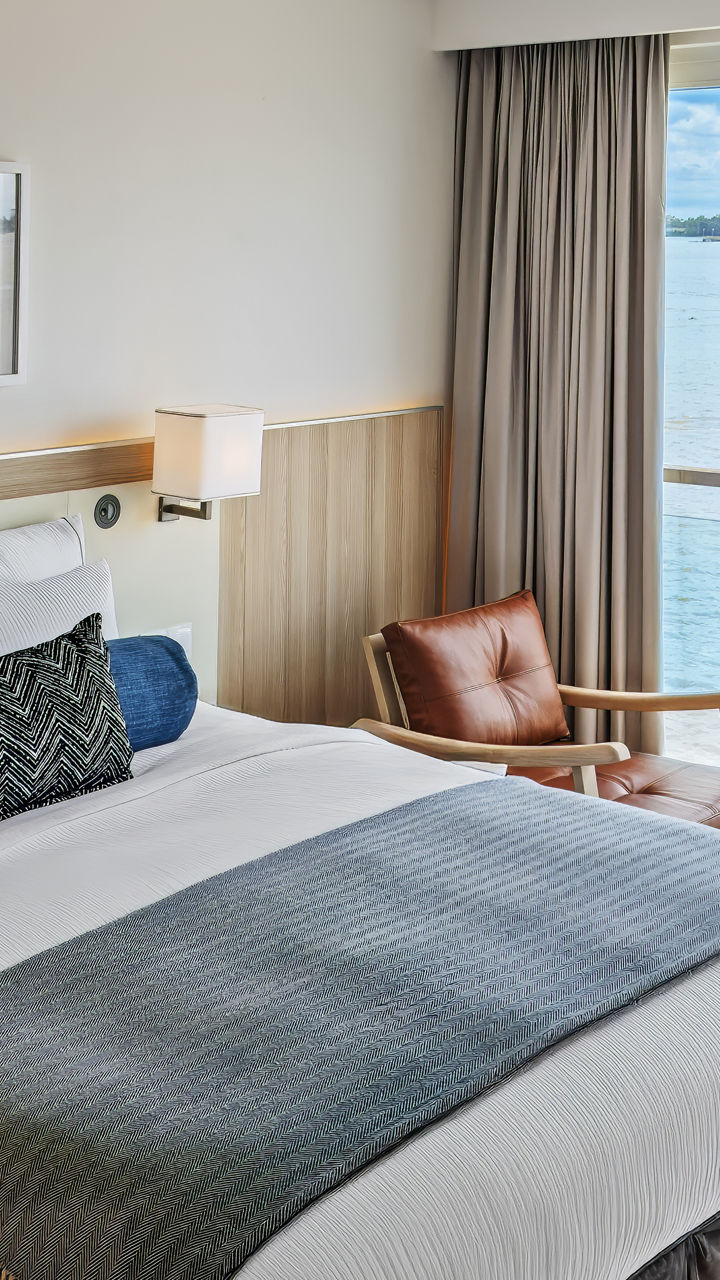 Modern hotel room with waterfront view and cozy decor