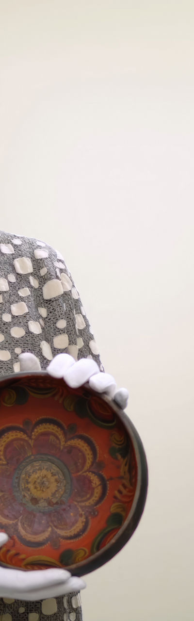 Person holding decorative ceramic bowl in storage