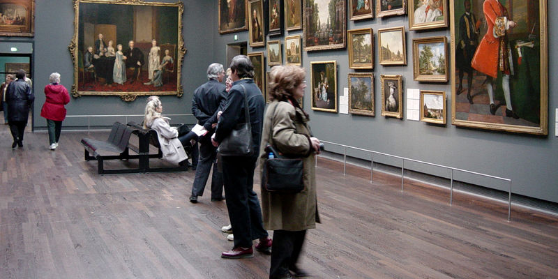 Art gallery visitors viewing classic paintings
