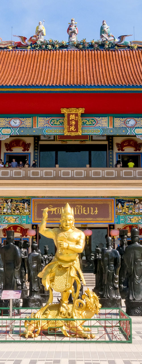 Colorful Chinese temple with statues under blue sky