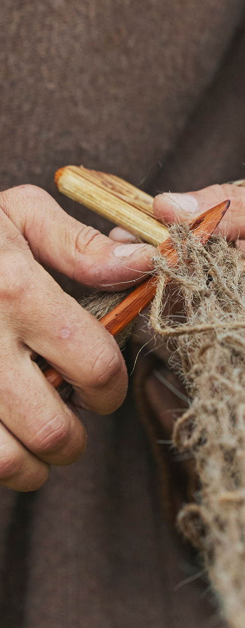 Hands crafting fishing net outdoors