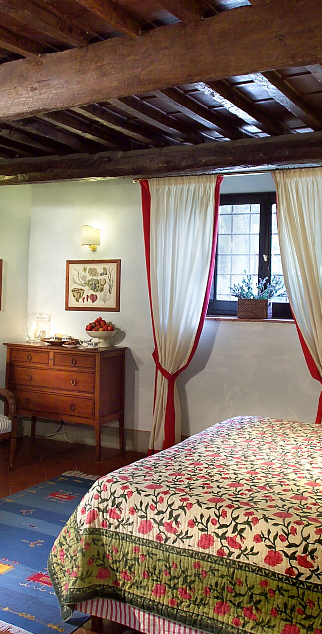Rustic bedroom with floral bedding and wooden beams