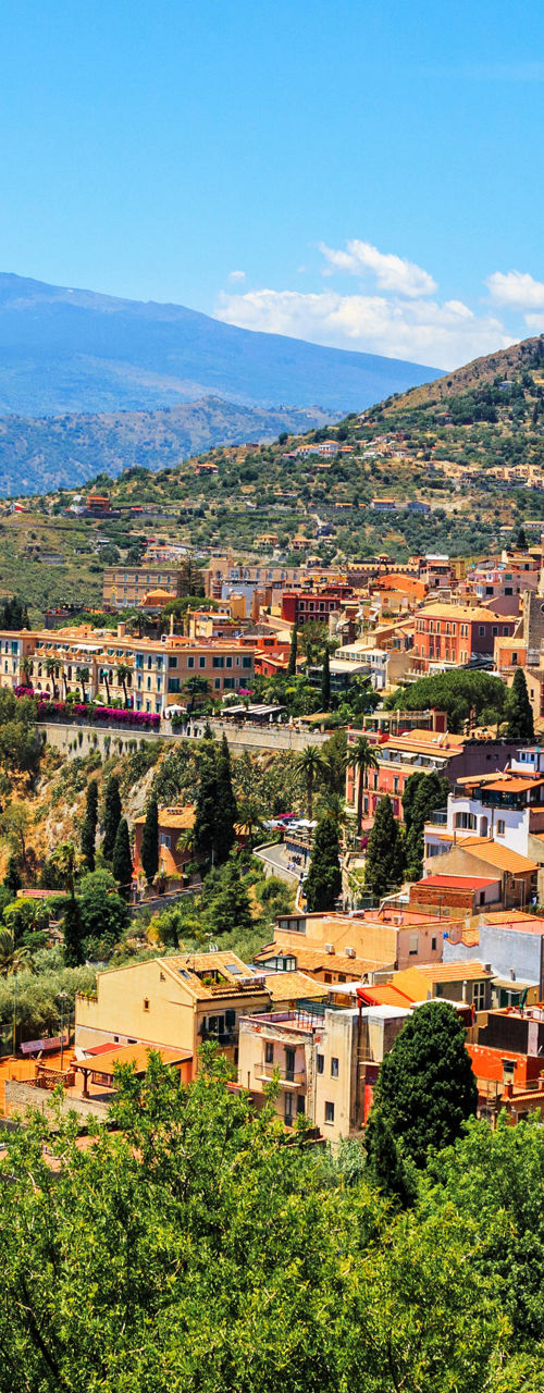 Scenic hillside town with mountain backdrop