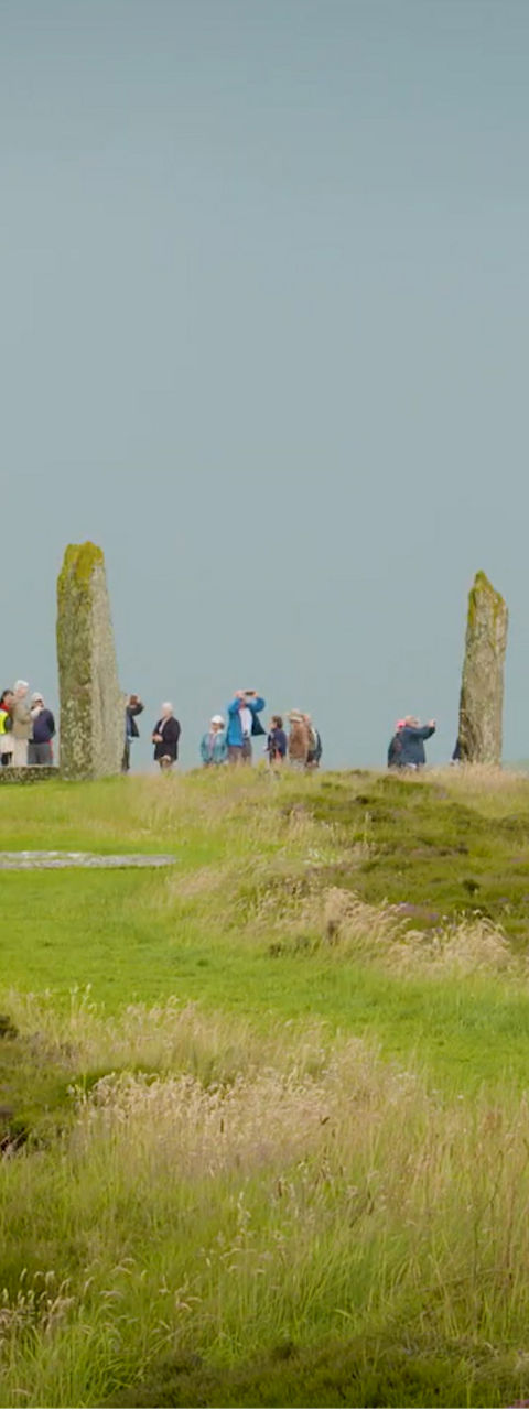 Tourists Visit Ancient Standing Stones in Countryside