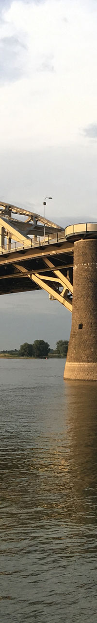 Golden arch bridge over calm river