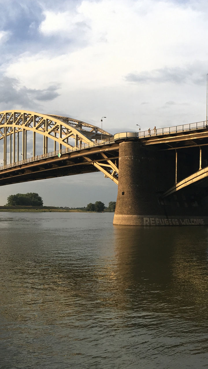 Golden arch bridge over calm river