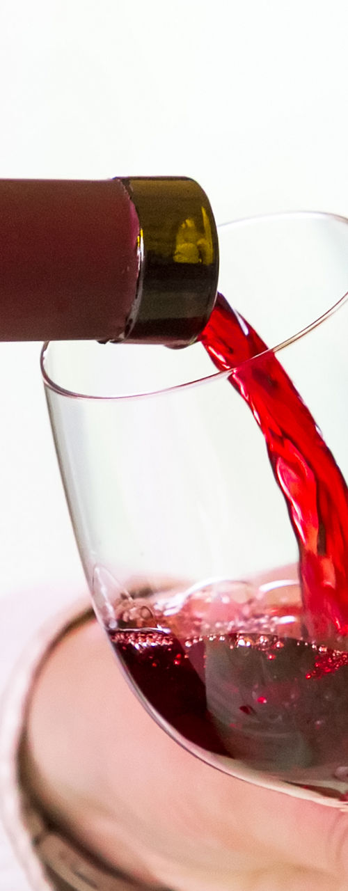 Red wine poured into glass at table