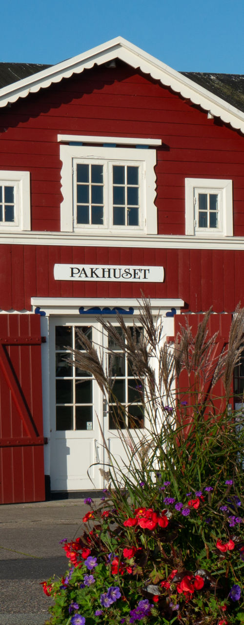Red wooden buildings with flower barrel