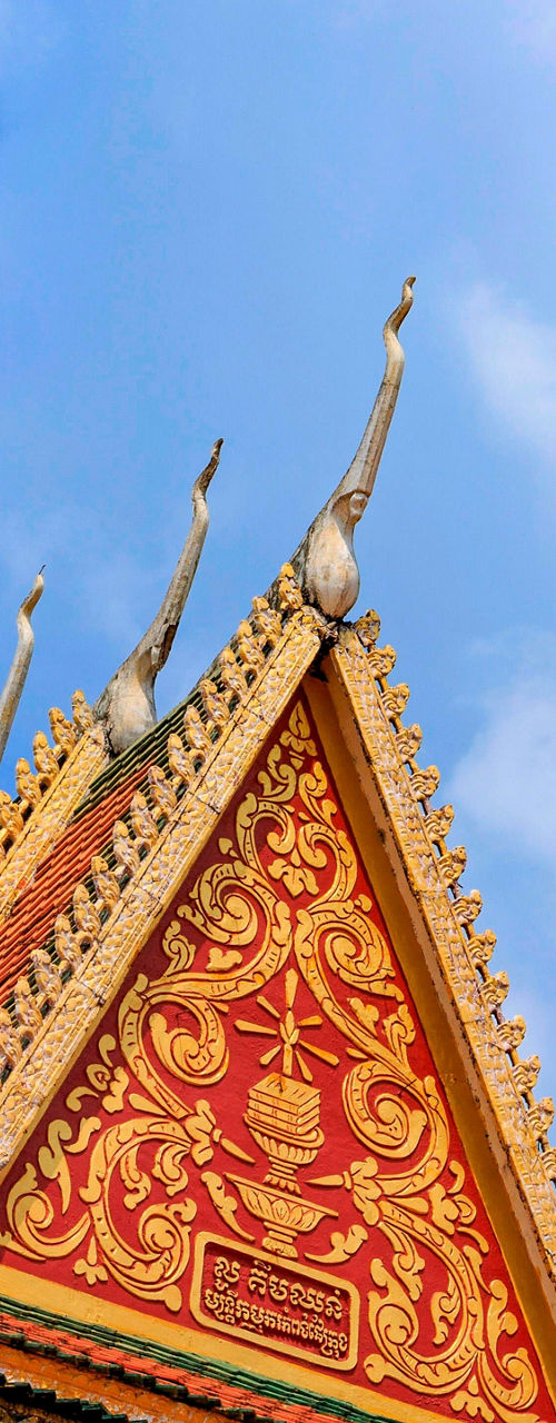 Ornate Buddhist temple roof under blue sky