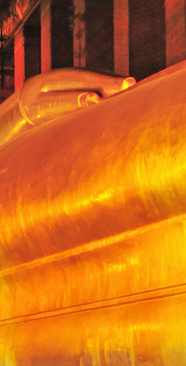 Golden reclining Buddha statue in ornate temple