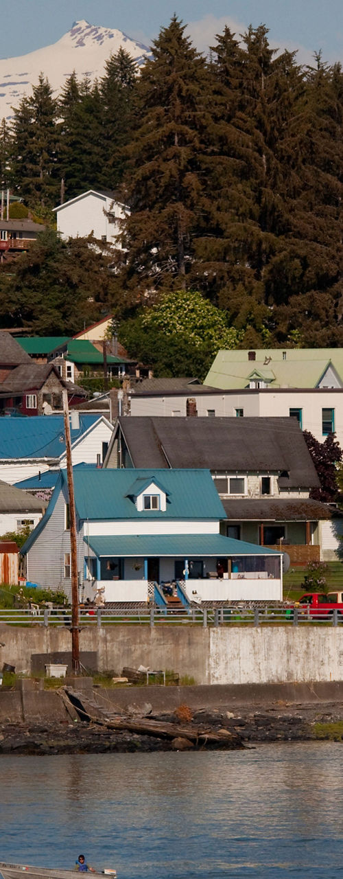 Scenic coastal town with mural and mountains