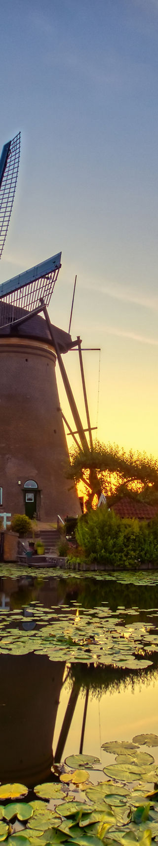 Traditional windmill at sunset by water