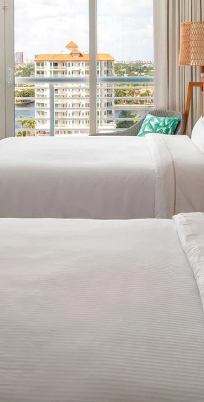 Modern hotel room with double beds and city view