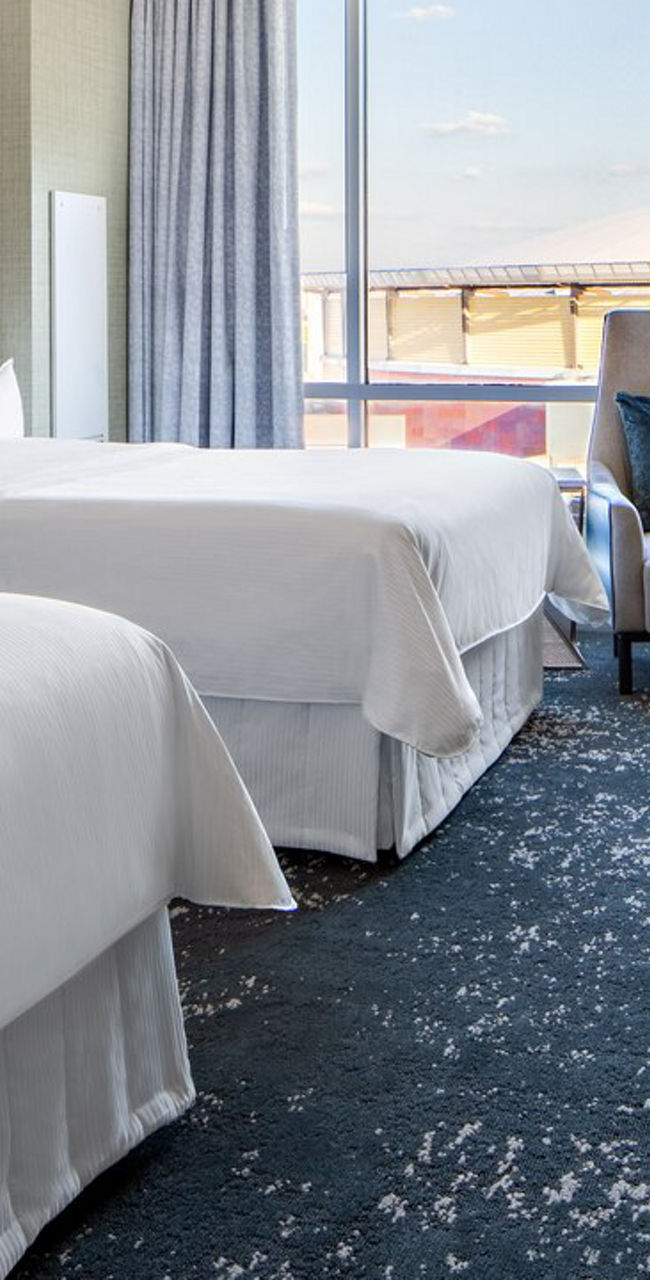 Modern hotel room with twin beds and city view