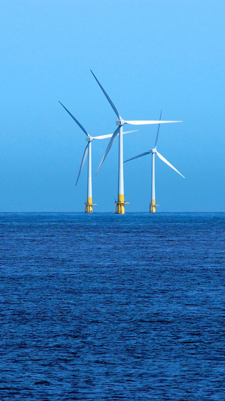 Offshore wind turbines in blue ocean