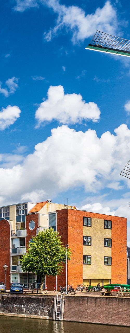 Traditional windmill beside modern waterfront housing