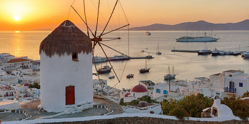 Sunset over Mykonos windmill and harbor