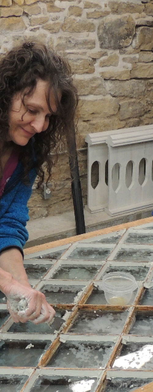 Two people restoring vintage glass window