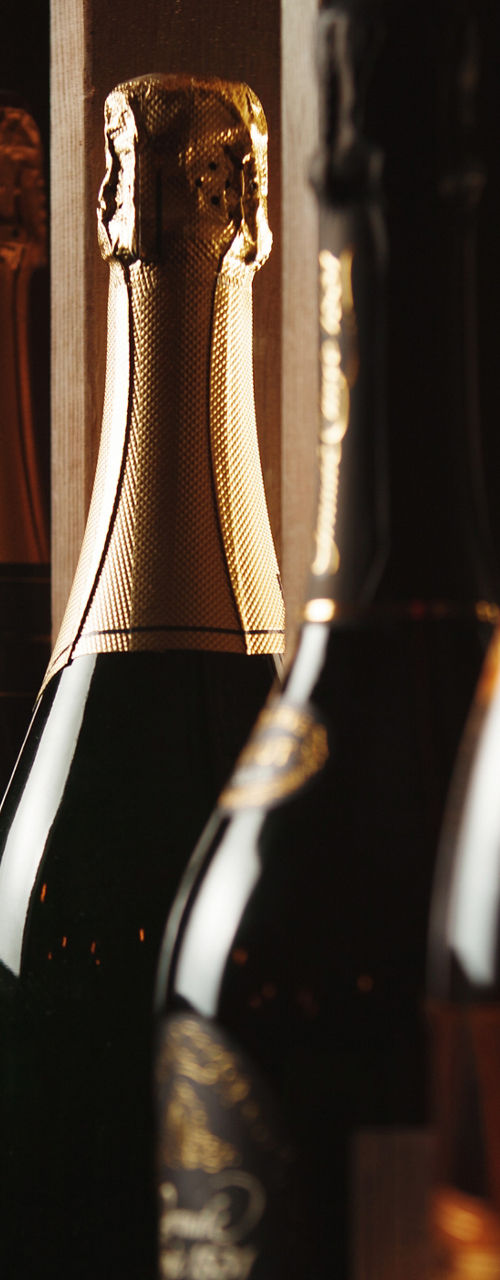 Assorted champagne bottles on wooden shelves